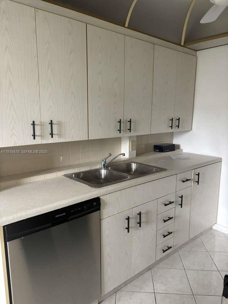 2052 Exeter C, Unit 2052 Boca Raton, FL 33434 - Photo 32 of 35 a kitchen with granite countertop white cabinets and sink