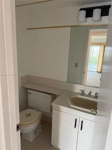 a bathroom with a toilet sink and mirror