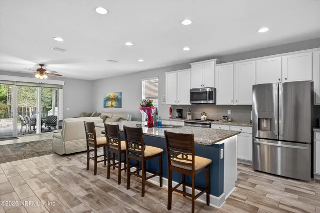 a view of kitchen with refrigerator stove dining table and chairs