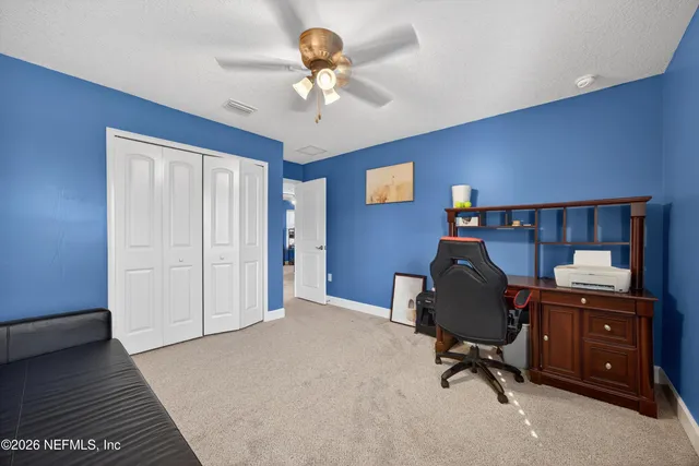a view of a workspace with furniture and a window