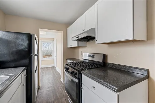 a kitchen with stainless steel appliances granite countertop a stove a sink and a microwave