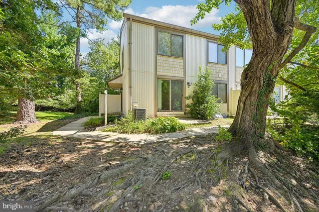 front view of a house with a yard and an trees