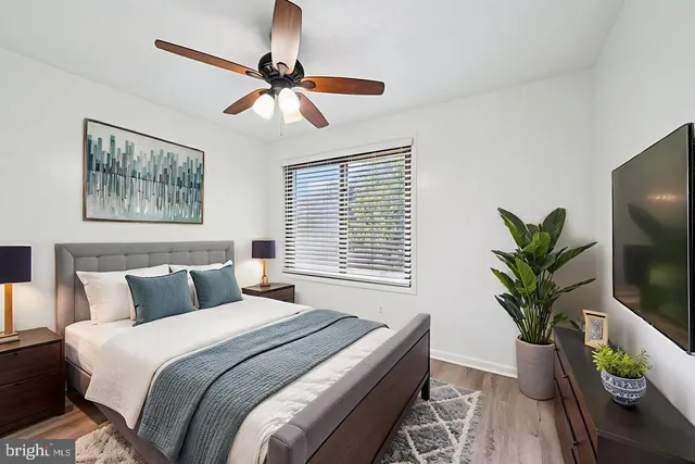 a bedroom with a large bed and a potted plant