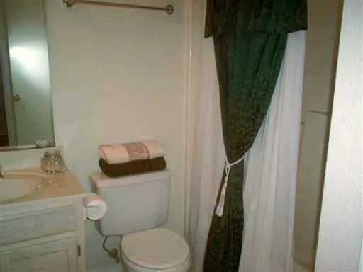 a white toilet sitting next to a bathroom sink and vanity
