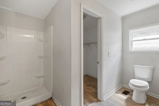 a bathroom with a toilet and a shower