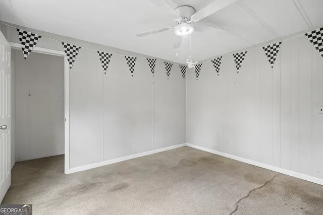 an empty room with a ceiling fan and a shower