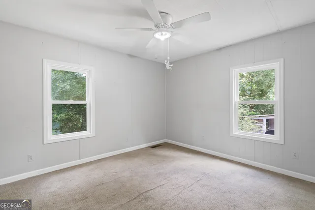an empty room with a window and a fan