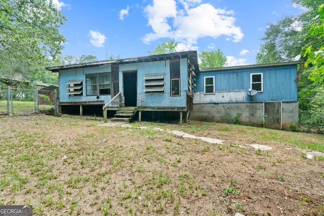 a view of a house with a yard and large tree