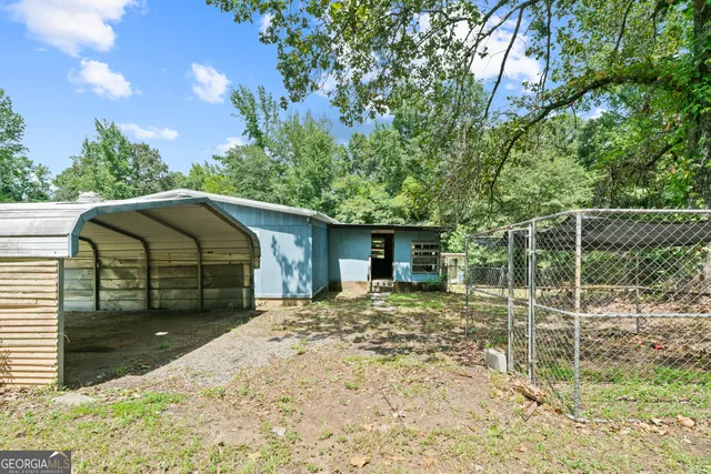 a view of a house with backyard and sitting area