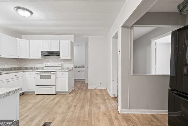 a kitchen with granite countertop white cabinets and white appliances