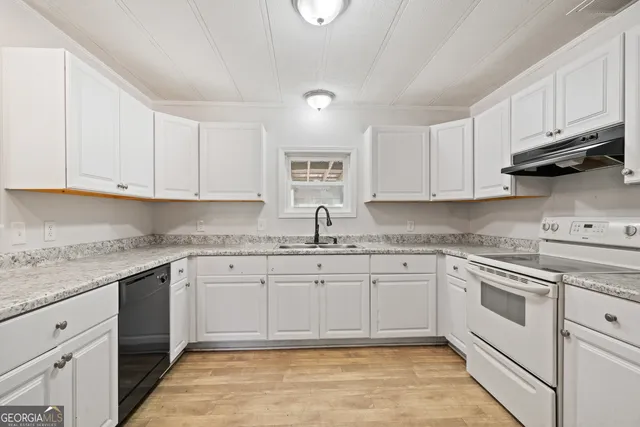 a kitchen with granite countertop cabinets stainless steel appliances a sink and dishwasher