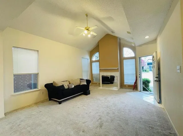 a living room with furniture a fireplace and a large window