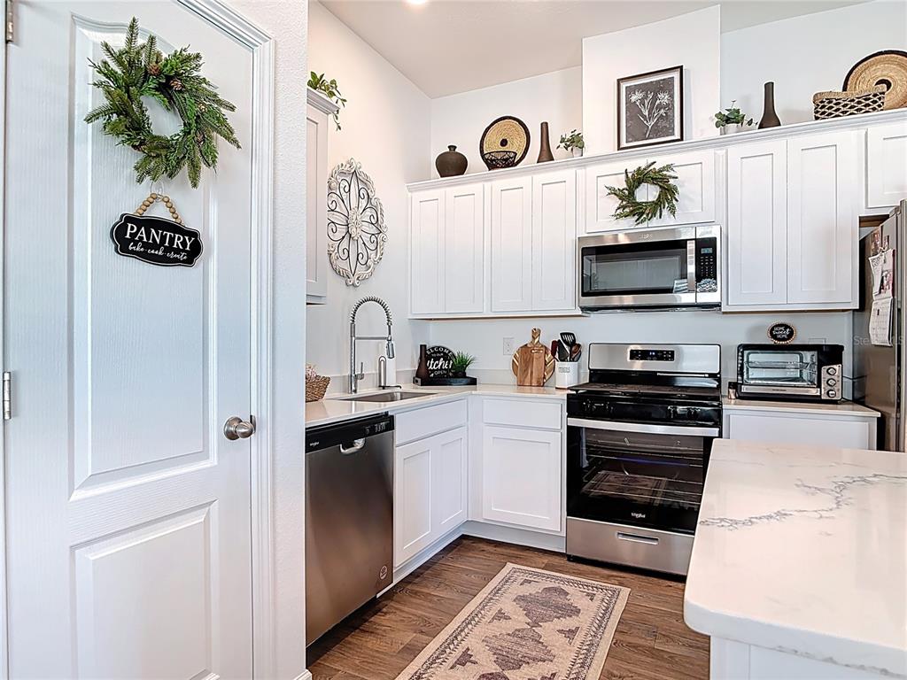 64 Bogey Place Bunnell, FL 32110 - Photo 13 of 55 a kitchen with stainless steel appliances a stove a microwave and cabinets