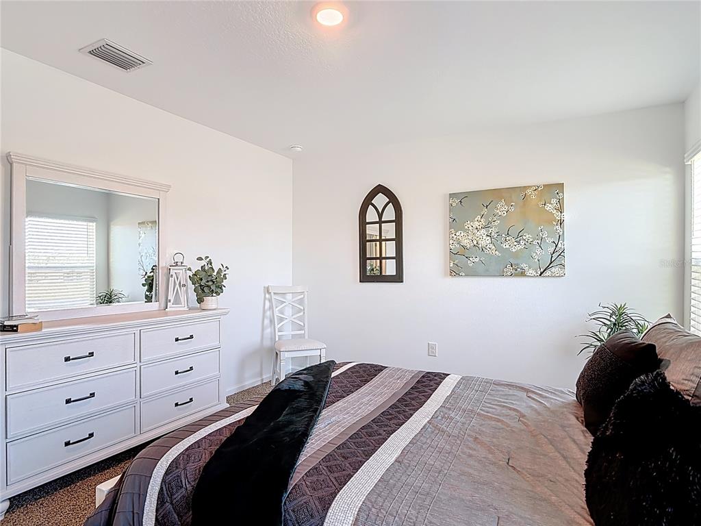 64 Bogey Place Bunnell, FL 32110 - Photo 23 of 55 a bedroom with a bed and a mirror on dresser