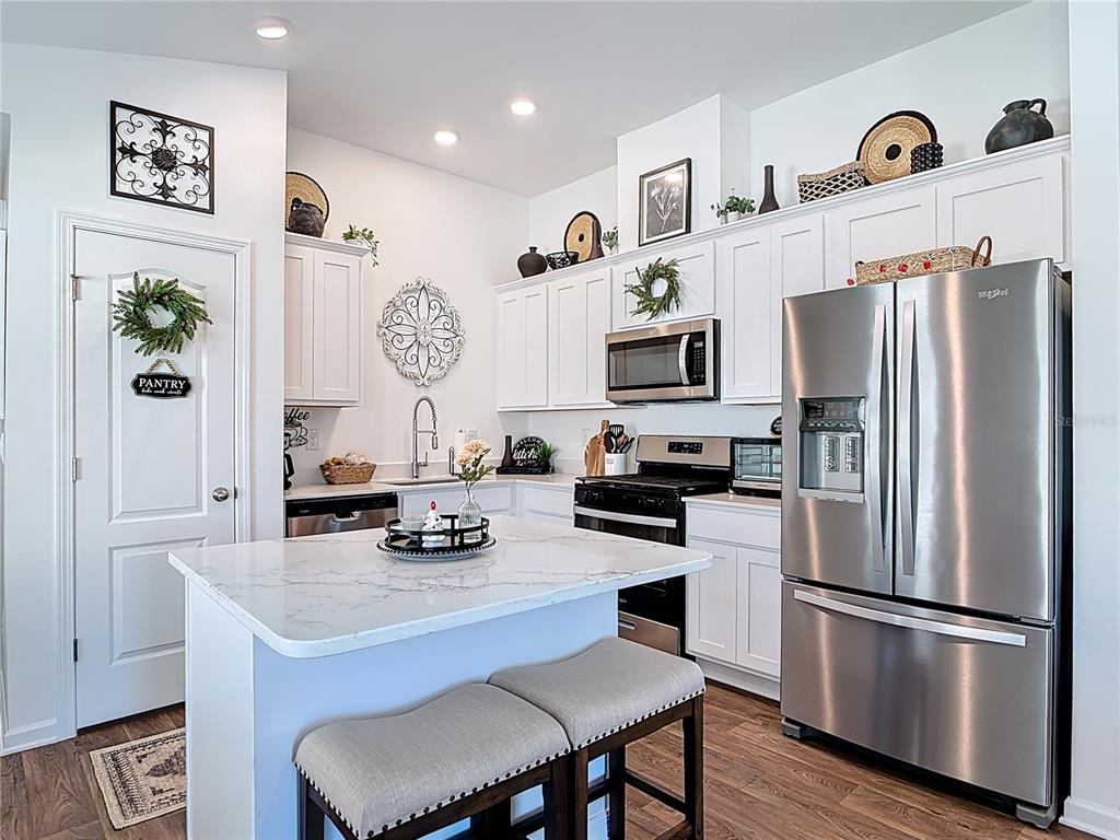 64 Bogey Place Bunnell, FL 32110 - Photo 6 of 55 a kitchen with stainless steel appliances a refrigerator a stove a sink and a refrigerator with wooden floor