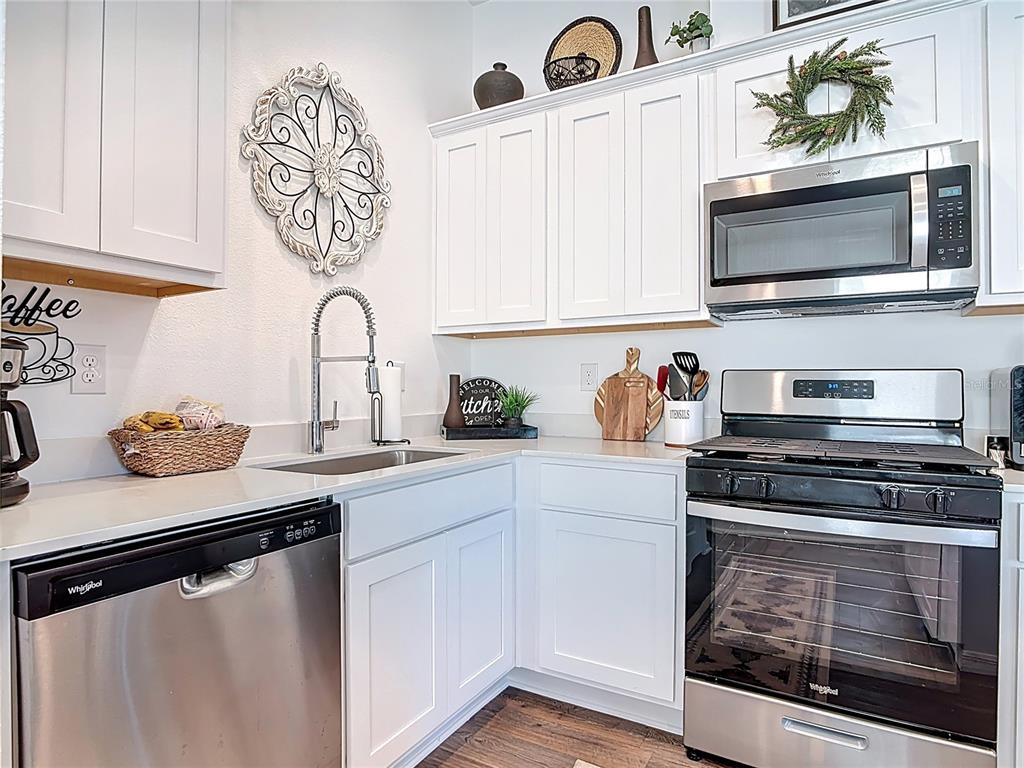 64 Bogey Place Bunnell, FL 32110 - Photo 9 of 55 a kitchen with stainless steel appliances a stove a microwave and cabinets