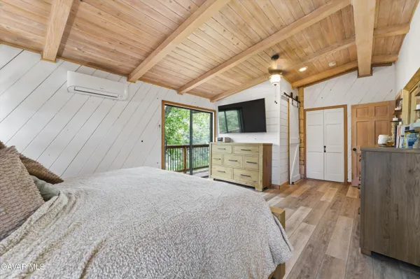a large bed sitting in a spacious bedroom next to a window