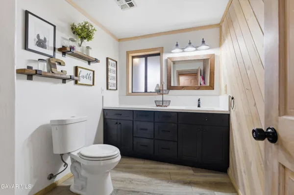 a bathroom with a toilet sink vanity granite and mirror