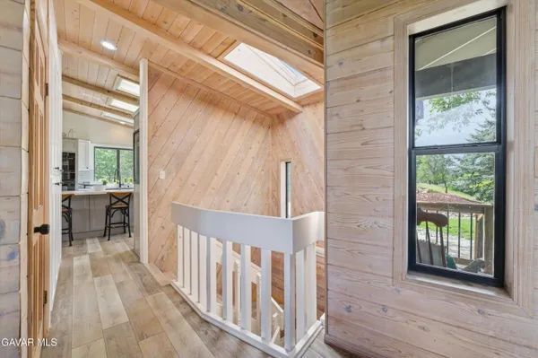 a living room with furniture floor to ceiling window and wooden floor