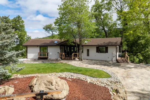 a front view of house with yard and trees around