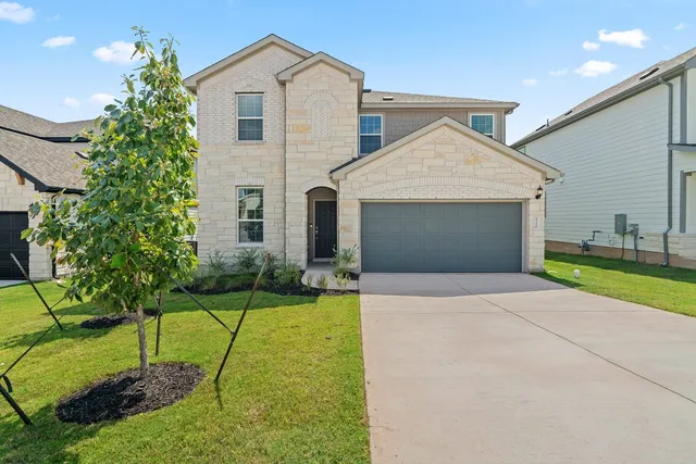 a front view of a house with a yard and garage