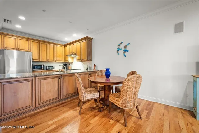 a kitchen with a table chairs refrigerator and cabinets