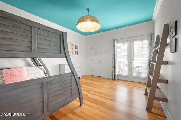 a view of a bedroom with wooden floor