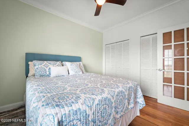 a large bed sitting in a bedroom next to a window and wooden floor