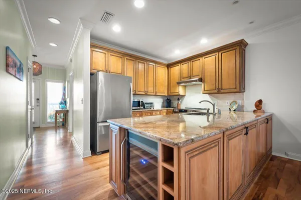 a kitchen with stainless steel appliances granite countertop a sink a stove and a refrigerator