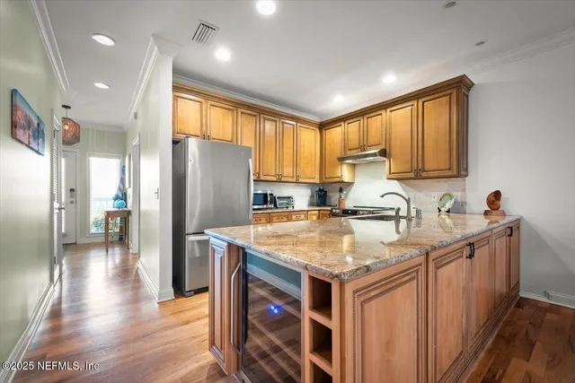 a kitchen with stainless steel appliances granite countertop a sink a stove and a refrigerator
