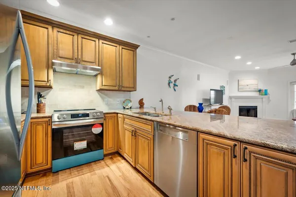 a kitchen with stainless steel appliances granite countertop a stove sink and cabinets