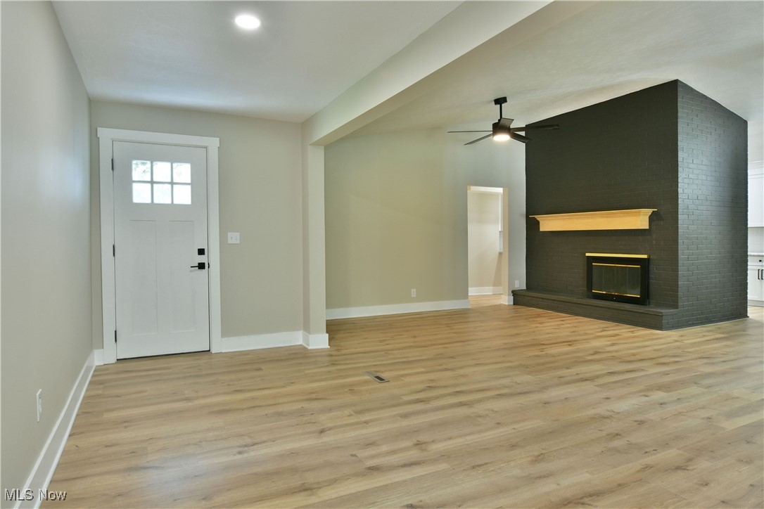 7655 Connelly Road Masury, OH 44438 - Photo 15 of 46 Entryway with a ceiling fan, light wood-style flooring, and a brick fireplace