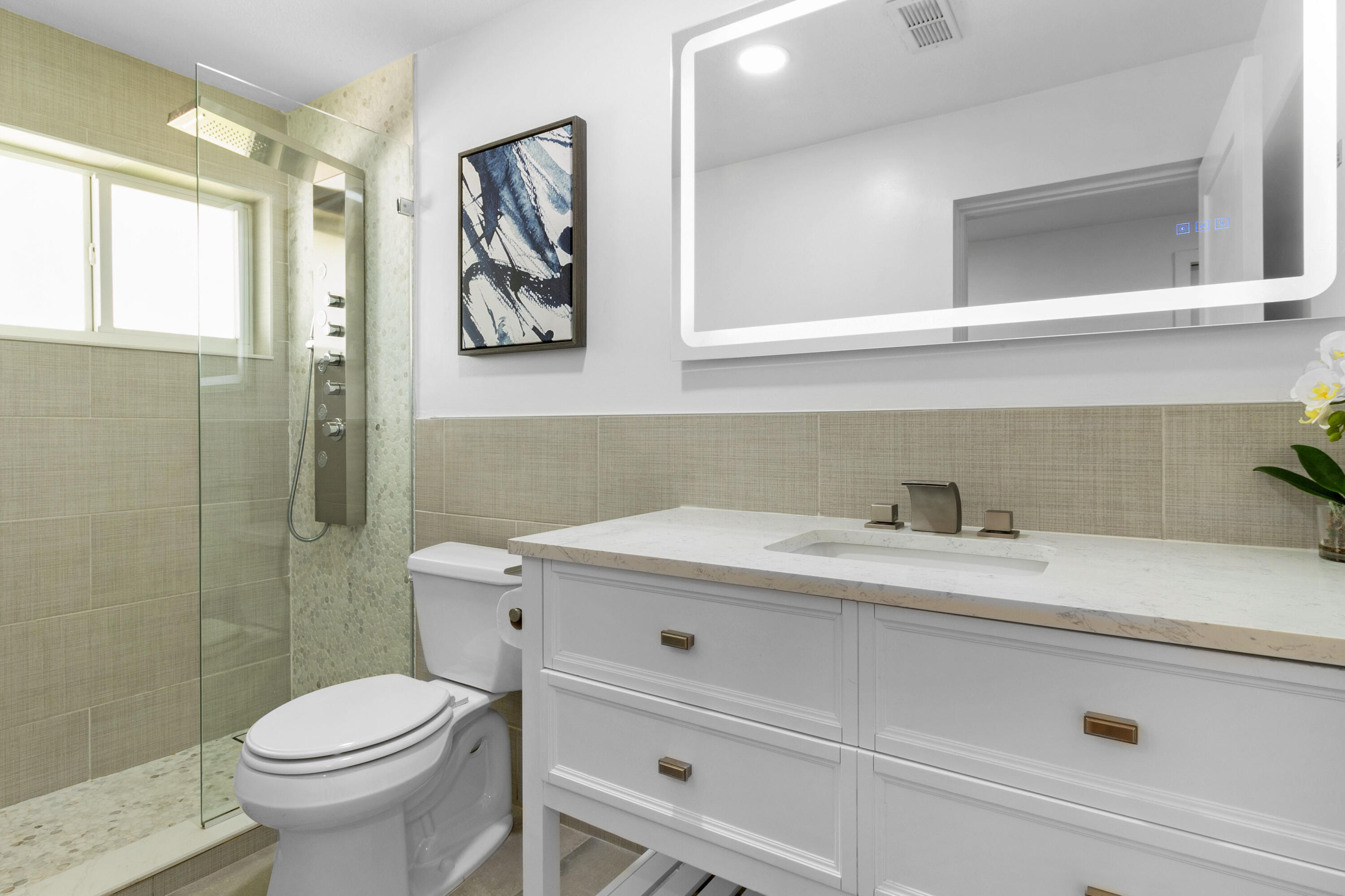 2862 Northeast 35th Court Lighthouse Point, FL 33064 - Photo 21 of 42 a bathroom with a sink a toilet and a mirror