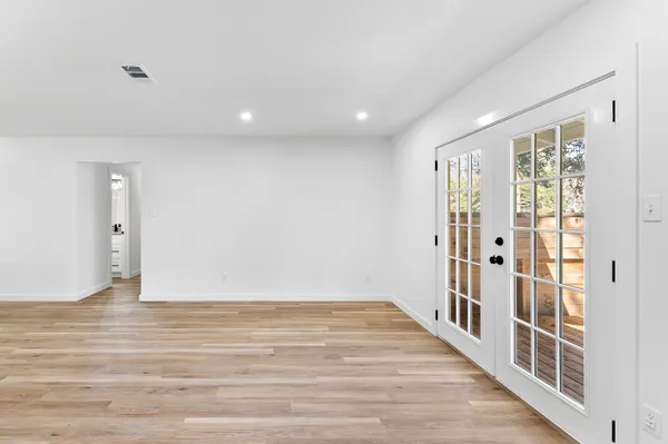 a view of a hallway with wooden floor and windows