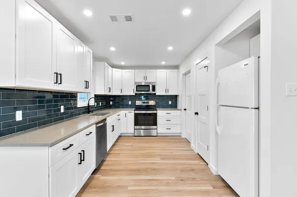 a large kitchen with white cabinets