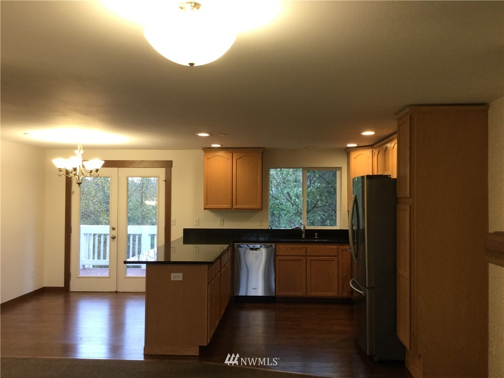 4606 Wood Place Everett, WA 98203 - Photo 5 of 37 a kitchen with stainless steel appliances granite countertop a refrigerator a sink dishwasher a stove and a large window with wooden floor