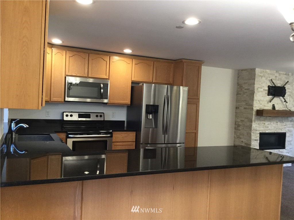 4606 Wood Place Everett, WA 98203 - Photo 7 of 37 a kitchen with kitchen island a counter top space cabinets stainless steel appliances and a window