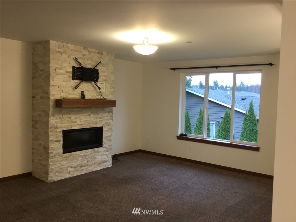 4606 Wood Place Everett, WA 98203 - Photo 8 of 37 a view of an empty room with a fireplace and a window
