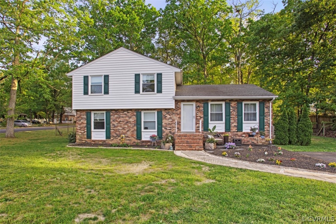 11901 West Petty Road Midlothian, VA 23113 - Photo 6 of 24 a front view of a house with a garden and trees