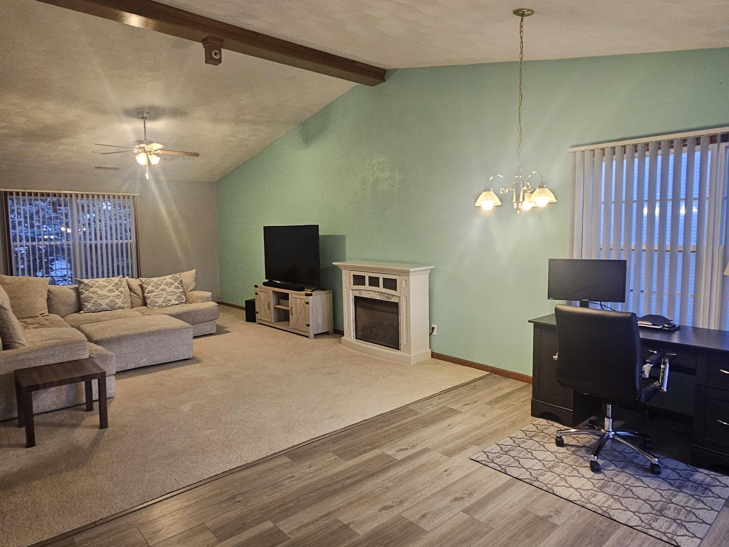 10167 Monarch Road Roscoe, IL 61073 - Photo 3 of 23 a living room with furniture a flat screen tv and kitchen view