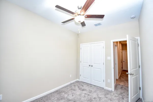 an empty room with a window and a ceiling fan
