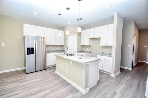 a large kitchen with a refrigerator and a stove top oven