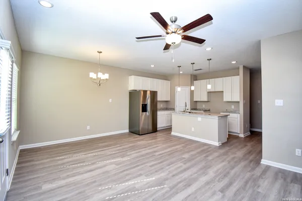 a large white kitchen with a sink and refrigerator