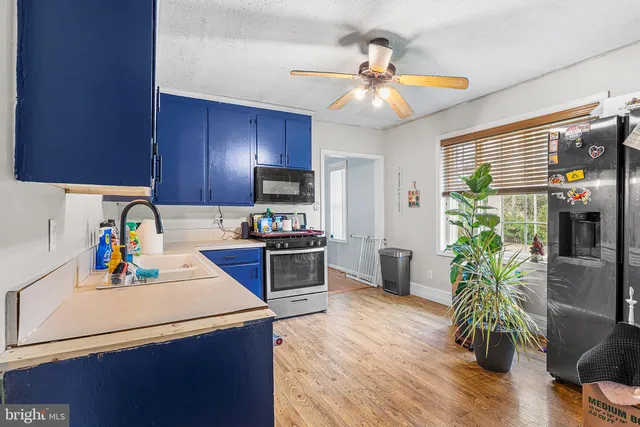 a kitchen with a refrigerator a stove cabinets and wooden floor