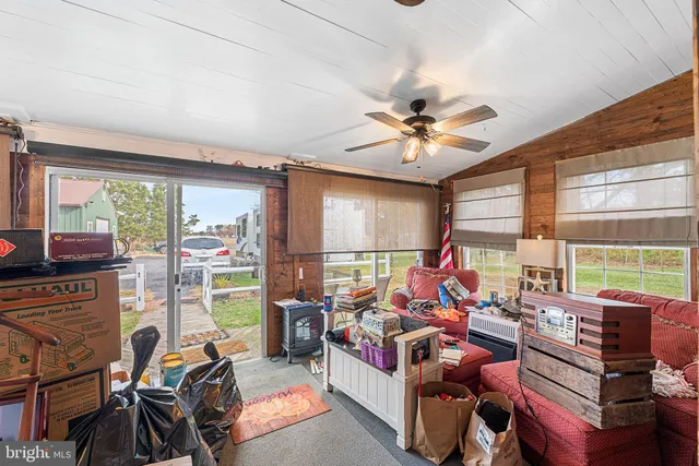 a living room with furniture a flat screen tv and a floor to ceiling window