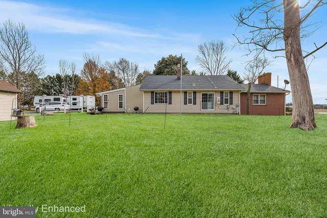 a view of a house with a big yard and large trees
