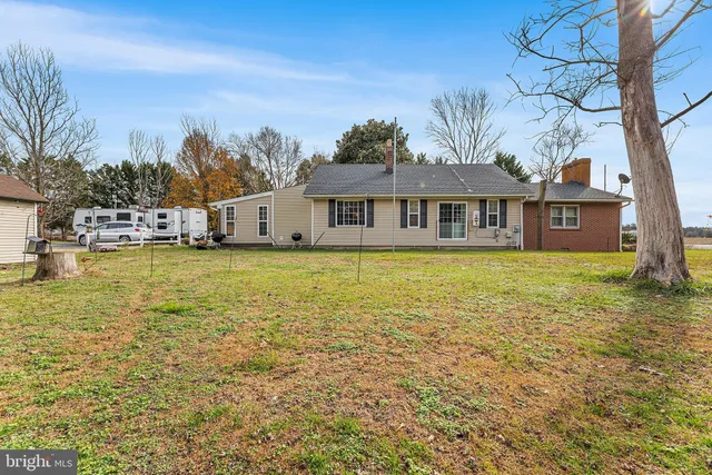 a view of a house with a big yard and palm trees