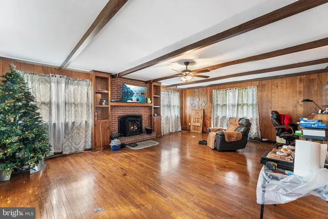 a view of a livingroom with fireplace dining space and wooden floor
