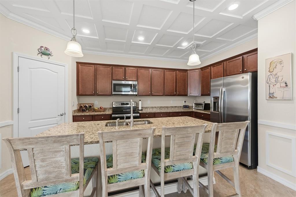 10475 Medjool Drive Venice, FL 34293 - Photo 22 of 71 a kitchen with stainless steel appliances granite countertop a stove a refrigerator a sink a stove a dining table and chairs