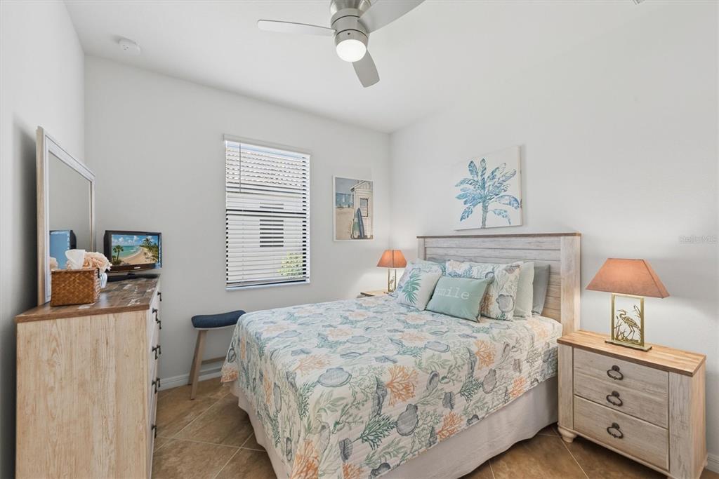 10475 Medjool Drive Venice, FL 34293 - Photo 33 of 71 a bedroom with a bed and a lamp on the dresser